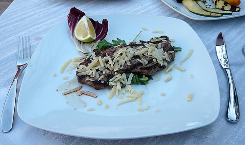 Geschnittenes Rinderfilet vom Grill mit Parmesan und Rucola